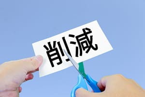 無駄の紙をハサミで切る