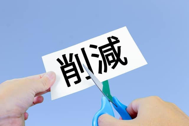 無駄の紙をハサミで切る